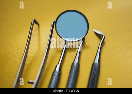 Close-up Strumenti Dentali su sfondo giallo. La prevenzione di malattie orali. Foto Stock