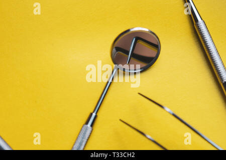 Close-up Strumenti Dentali su sfondo giallo. La prevenzione di malattie orali. Foto Stock