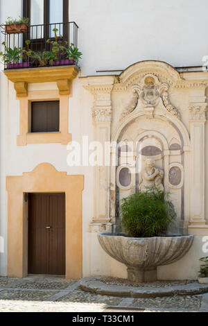 Tipica siciliana di Palazzo cortile e architetture riccamente ornate con ghisa balcone e ciottoli pavimentazione in città di Palermo, Sicilia, Italia Foto Stock