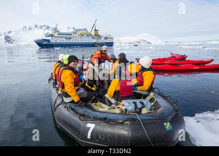 Kayak da mare con turisti provenienti da un'Antartide la nave di crociera nel canale di Lemaire, Graham Land, Antartico peninsulare. Foto Stock