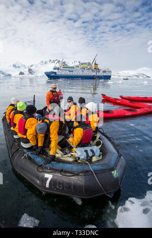 Kayak da mare con turisti provenienti da un'Antartide la nave di crociera nel canale di Lemaire, Graham Land, Antartico peninsulare. Foto Stock