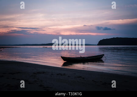 Tramonto sul mare con una barca. Una foto di una piccola barca con un bel tramonto sullo sfondo. Andamane e Nicobar India. Foto Stock