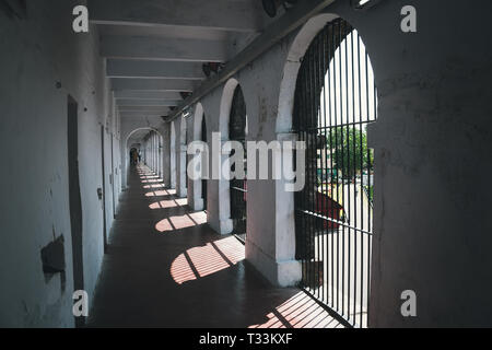 Corridoio abbandonati nella vecchia prigione. Lungo corridoio in carcere cellulare, Port Blair, isole Andaman, India. Confino solitario celle lungo il muro bianco Foto Stock