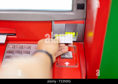 Mano di uomo utilizzando un bancomat con la carta di credito. Foto Stock