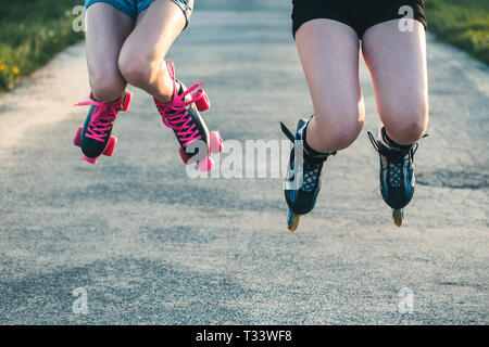 Le ragazze adolescenti divertendosi rollerskating, saltando e trascorrere del tempo insieme sul giorno di estate Foto Stock