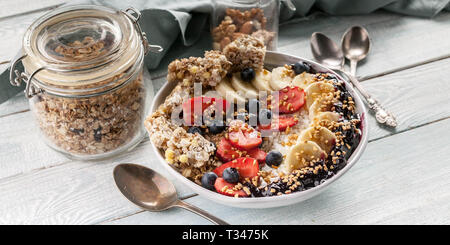 Banner di cibo. Colazione Biologica. Cottage cheese, granola, banane, fragole, mirtilli e riso soffiato. Tavolo in legno sfondo Foto Stock