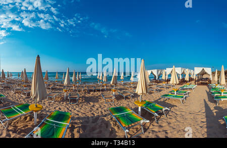 Mattina paradise spiaggia di sabbia bianca con ombrelloni e sdraio (salento Puglia sud Italia). Il più bel mare spiaggia sabbiosa della Puglia. Foto Stock