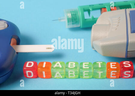 Parola diabete accanto all'insulina, penna a lancia, sangue striscia di prova di glucosio e glaucometer digitale Foto Stock