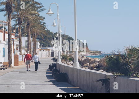Coppia senior camminando lungo una spiaggia promenade, Malaga, Spagna Foto Stock