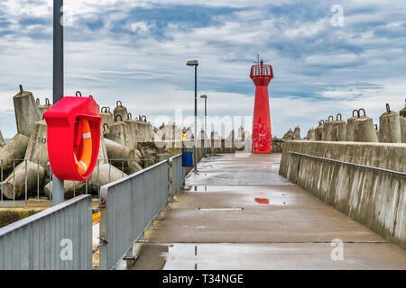 Il faro rosso è un cosiddetto pier luce e segna l'entrata al porto di Kolobrzeg, West Pomerania, Polonia, Europa Foto Stock