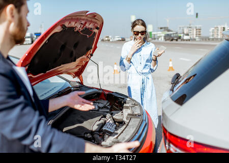 Due driver di ispezione di danneggiamento auto dopo l'incidente di traffico sulla strada della città Foto Stock