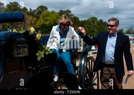 Pinehurst, North Carolina, Stati Uniti d'America. 3 apr, 2019. 6 aprile 2019 - Pinehurst, N.C., STATI UNITI D'AMERICA - Villaggio di Pinehurst sindaco NANCY FIORILLO è scortato dal pastore JIM EWING alla via per la cerimonia di apertura al settantesimo annuale di primavera cablaggio Matinee gare sponsorizzato dalla Pinehurst Guidare & Training Club, al Pinehurst via cavo, Pinehurst, North Carolina. Questo anno di gare commemorare il 104th anniversario della pista. Credito: Timothy L. Hale/ZUMA filo/Alamy Live News Foto Stock