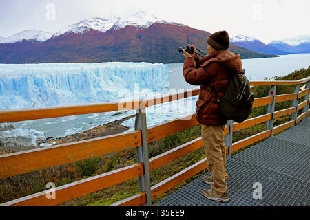 Uomo a scattare foto del ghiacciaio Perito Moreno dal lungomare nel parco nazionale Los Glaciares, El Calafate, Patagonia, Argentina, Sud America Foto Stock