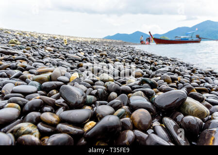 Barca dalla coda lunga portano i turisti viaggiare a Ko Hin Ngam isola e bella roccia con uno strano colore nero è un famoso attrazioni di Tarutao National Foto Stock