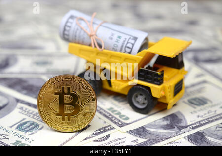 Bitcoin è sullo sfondo del dumper, che è caricato con un fascio di fatture del dollaro. Il concetto di prezzi elevati Bitcoin contro il dollaro USA Foto Stock