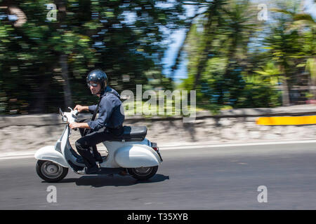 Giovane uomo italiano corse scooter Vespa sulla strada costiera a Sorrento Italia Foto Stock