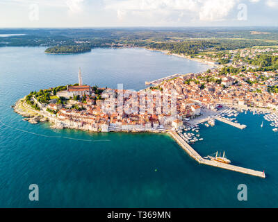 Città croata di Rovigno su un litorale di blu azzurro turchese del Mare Adriatico, lagune di Istria e Croazia. Alta torre campanaria, tetti di tegole rosse di hi Foto Stock