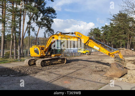 Giallo cingolati Caterpillar JCB JS130 LC impianto pesante escavatore escavatore cingolato con benna convogliatore ad RHS Gardens, Wisley, Surrey, Regno Unito Foto Stock