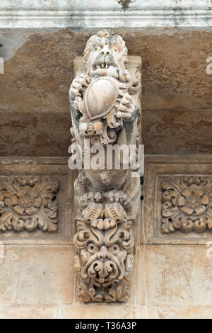 Antico in pietra mitico lion e gargoyle sul Palazzo Nicolaci di Valladorata in stile barocco della città di Noto, Sicilia Foto Stock