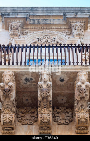 Antico in pietra mitico cavalli e doccioni sul Palazzo Nicolaci di Valladorata in stile barocco della città di Noto, Sicilia Foto Stock