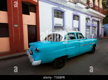 Blu e bianco 1952 Ford Customline Sedan quattro porte guida su strada con i suoi edifici colorati a l'Avana, Cuba Foto Stock