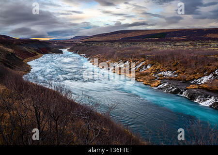 Hraunfossar ("cascate di lava" in inglese) nel distretto di Borgarfjörður è una serie di belle cascate formate da ruscelletti streaming fuori del Hallmundar Foto Stock