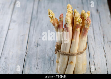 Bundle di prodotti freschi con la buccia asparagi bianchi in primavera Foto Stock