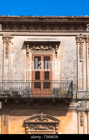 Tradizionale tipica architettura siciliana balcone, persiane e ornati in muratura in pietra a Piazza San Giovanni a Ragusa Ibla, Sicilia Foto Stock