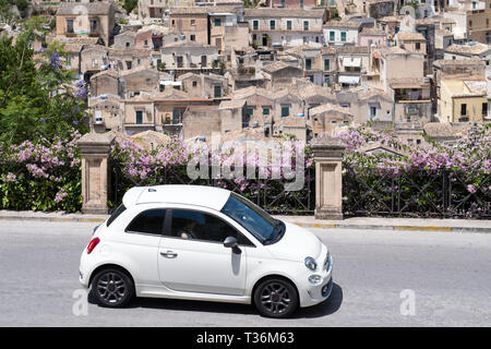 Colore bianco 500 Fiat Cinquecento in collina città di Modica Alta guardando verso Modica Bassa, Sicilia, Italia Foto Stock