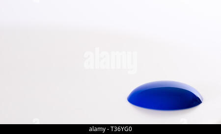 Close up di blu blob di vernice su sfondo bianco Foto Stock