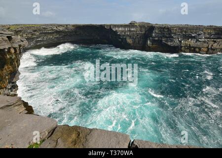 Inishmore, una delle Isole Aran in Irlanda. Scogliere e un oceano turchese. Dún Dúchathair in background. Foto Stock