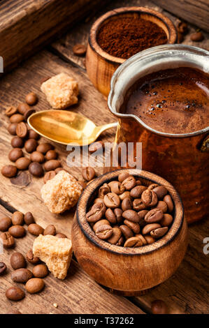 Il caffè torrefatto in grani e macinato.i chicchi di caffè su uno sfondo di legno Foto Stock