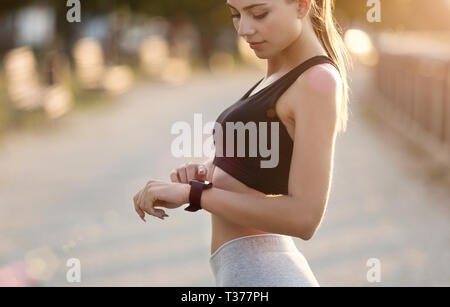 Donna Moderna il controllo dei dati di allenamento al fitness tracker Foto Stock