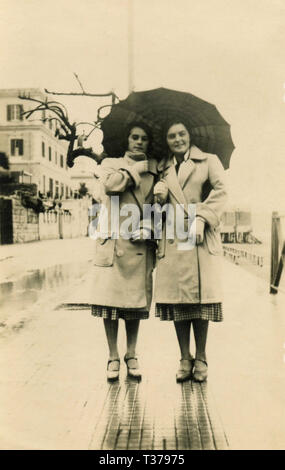 Le donne gemelli vestiti uguali sotto lo stesso ombrello, Italia 1931 Foto Stock