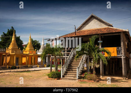 Cambogia, Kampong (Kompong Cham), Wat Dei Doh, monastero Buddista, dipinte e stupa dorato accanto a Monaco tradizionale's house Foto Stock