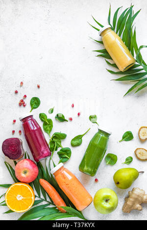Detox cibo e pulire il concetto di mangiare. Vari i frullati o succhi di frutta in bottiglie e ingredienti su bianco, vista dall'alto, copia dello spazio. Foto Stock