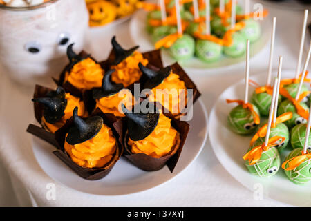 Tortine con crema di colore arancione e nero dolce cappelli sul candy bar per la festa di Halloween. Foto Stock
