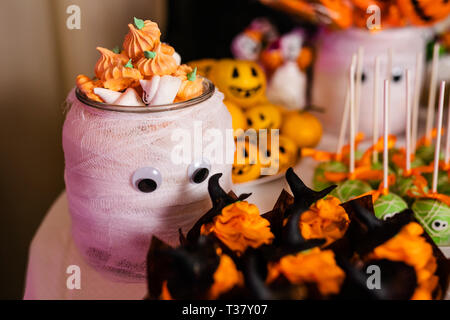 Grande Vaso decorato con zucca marshmallows sul candy bar per la festa di Halloween. Foto Stock