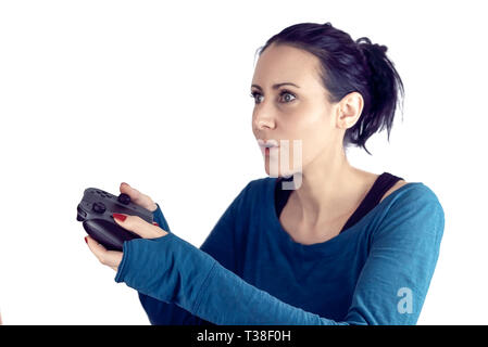 Giovane donna con il maglione blu la riproduzione del video gioco su wireless controller di gioco con un concentrato di espressioni facciali isolato su bianco Foto Stock