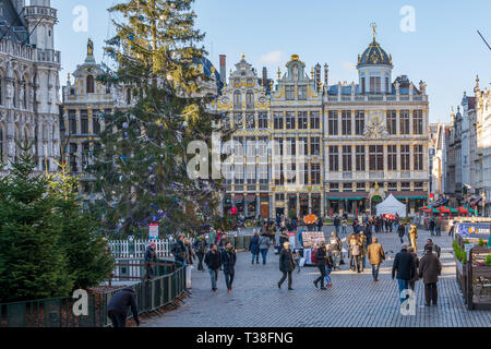 I turisti alla famosa Grand Place Bruxelles, con ricche decorazioni scultoree guild houses facciate e alberi di Natale. Foto Stock