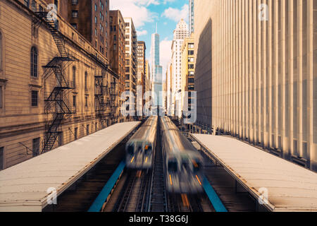 I treni arrivano alla stazione ferroviaria tra gli edifici nel centro di Chicago, Illinois. I mezzi di trasporto pubblici, usa un punto di riferimento o città americana concetto LIFE Foto Stock