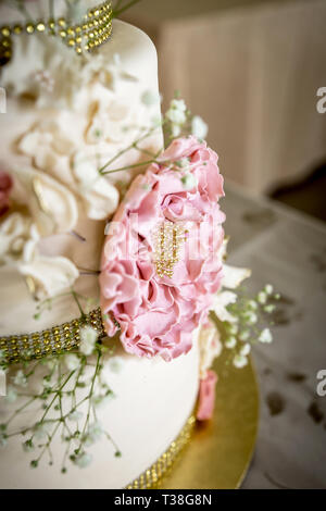 Torta di Nozze con bianco e rosa di fiori di zucchero e oro topper Foto Stock