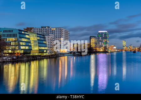 Il fiume Sprea a Berlino di notte con edifici moderni presso le sponde del fiume Foto Stock