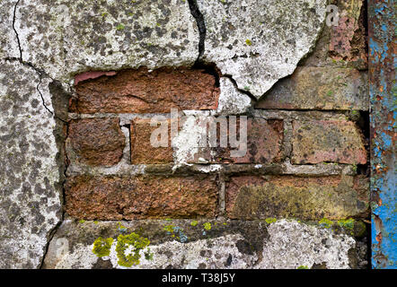 Sfaldatura e rotto rivelando di rendering cotto su condannato abbandonati edificio di fabbrica in attesa di demolizione Foto Stock