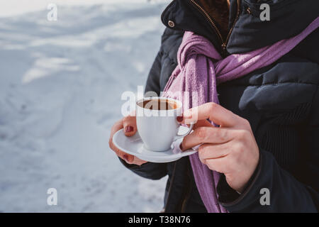 Mani femminili coppa di ritegno con caffè caldo in tazza bianca. Foto Stock