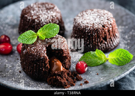 Torte al cioccolato con nucleo fuso decorato con foglie di menta. Primo piano. Lava Torta al cioccolato Foto Stock