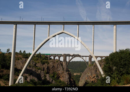 Contenitore treno merci attraversando arch ponte ferroviario attraverso Ulla river in Pontevedra, Spagna Foto Stock
