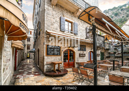 Un outdoor cafe si trova a vuoto la mattina presto nel centro turistico della medioevale città murata di Kotor, Montenegro Foto Stock