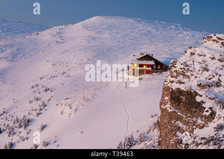 Paesaggio di sunrise al rifugio di montagna, inverno mattina scena in Carpazi romeni, Ceahlau Mountain Foto Stock