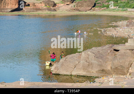 Le donne a lavare i panni sulle rive del lago Agastya in Badami, Karnataka, India Foto Stock